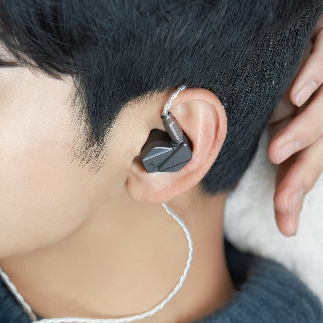 Astell&amp;Kern AK ZERO2 with attached stock cable inserted into human ear