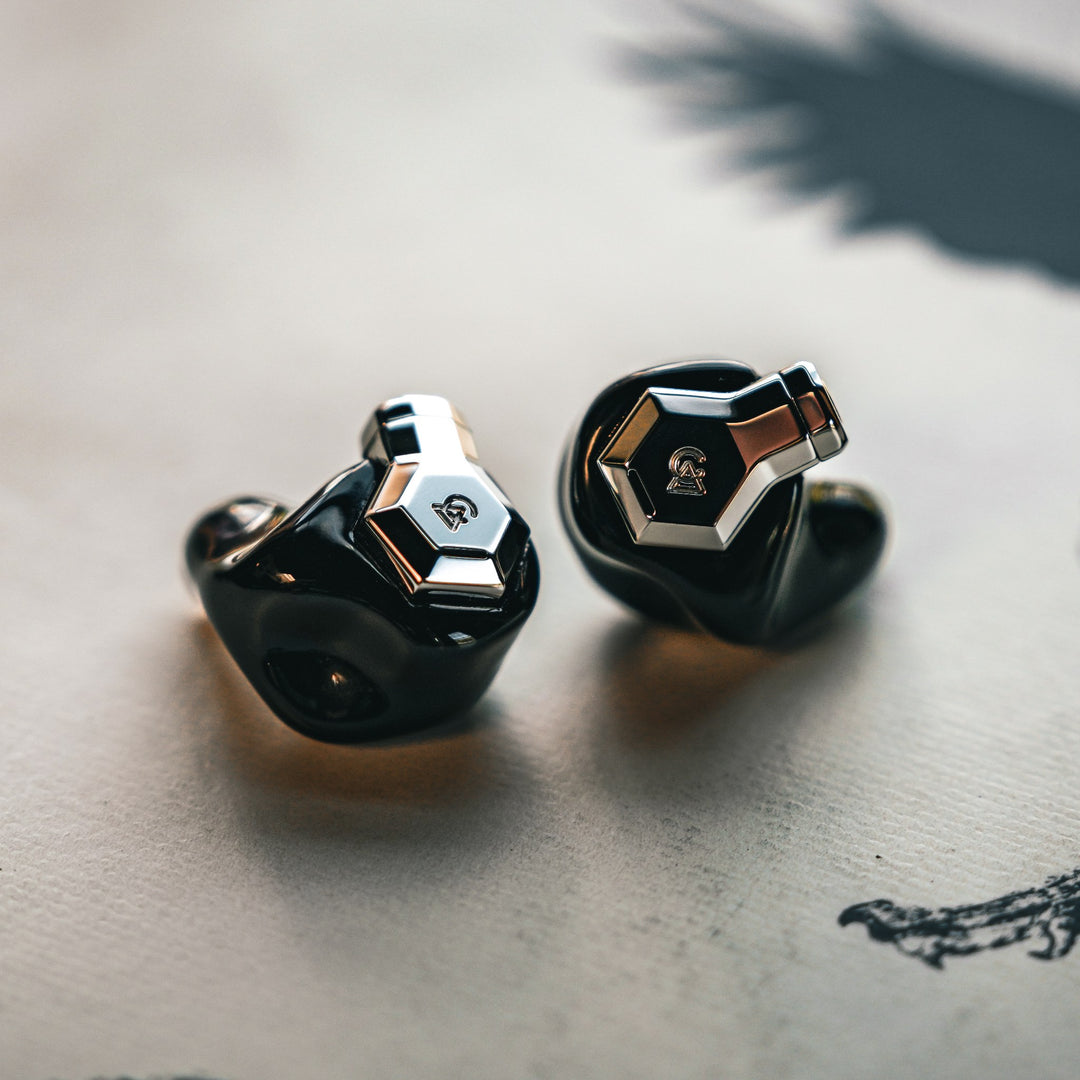 Campfire Audio Ponderosa black earphones warm dramatic front 3 quarter over cream vinyl disc