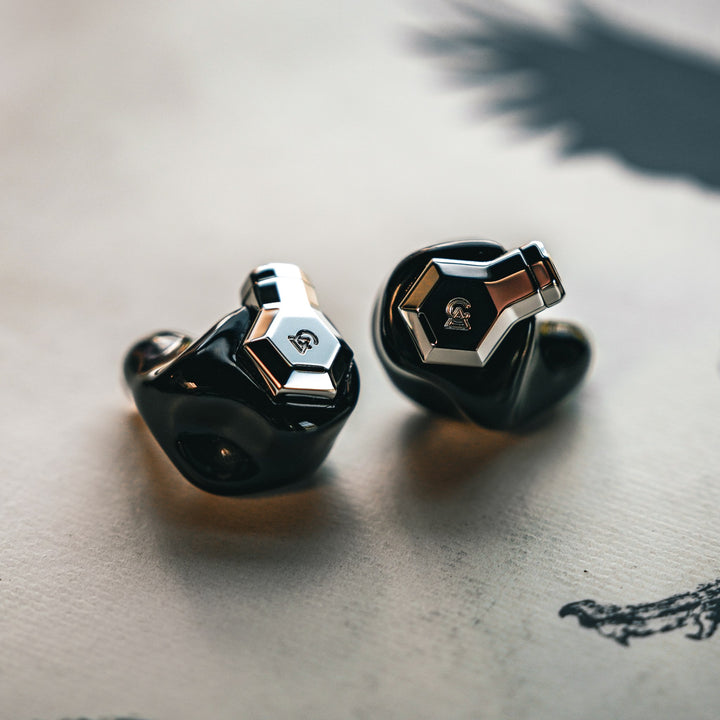 Campfire Audio Ponderosa black earphones warm dramatic front 3 quarter over cream vinyl disc
