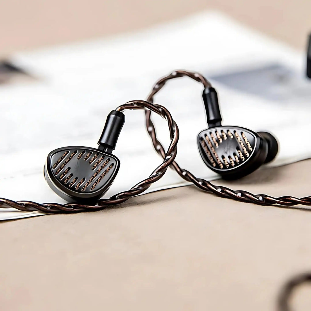 Kiwi Ears Septet IEMs sitting face forward with cable attached on top of infographic