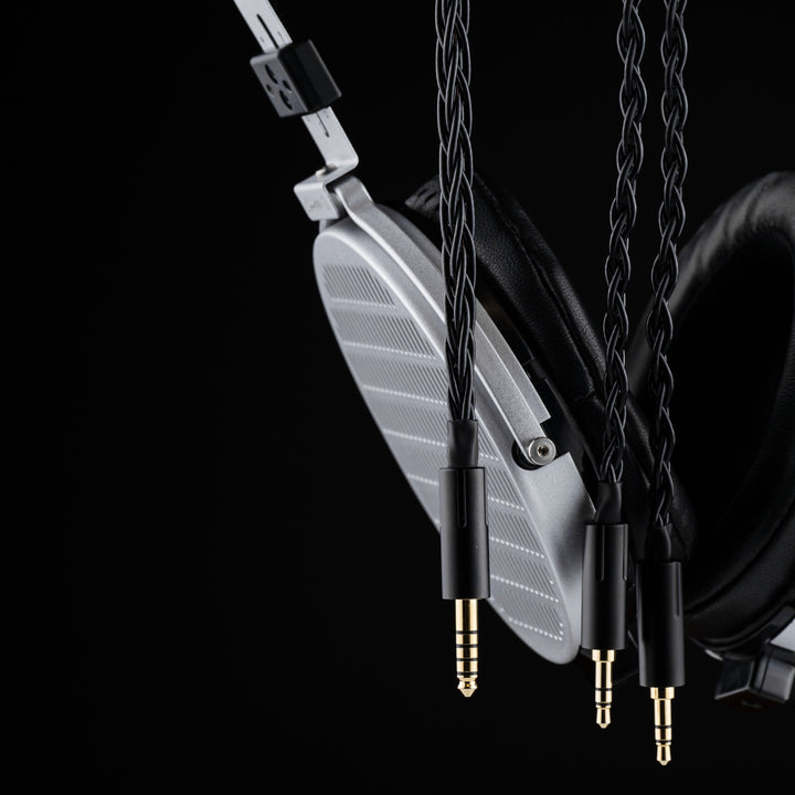 Moondrop Cosmo closeup grill with hanging stock cable highlighting plugs over black background