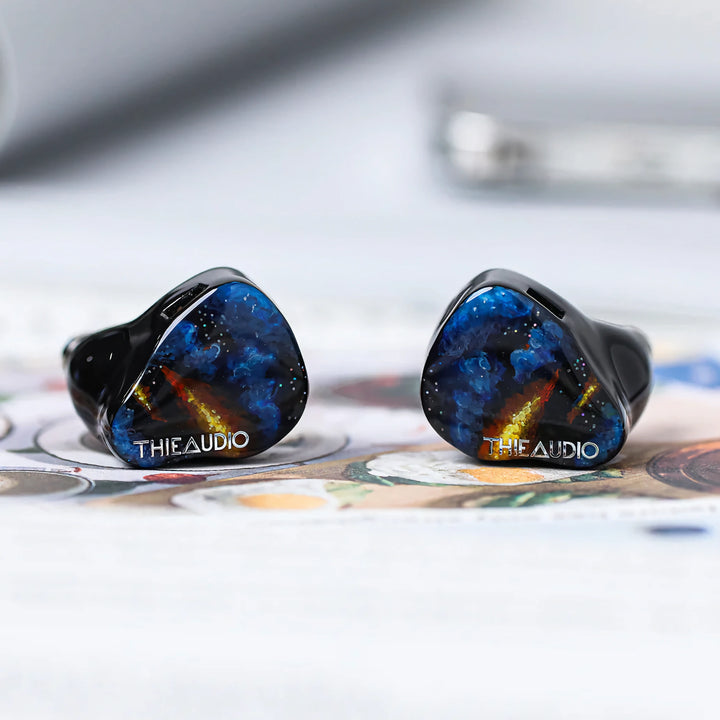 ThieAudio Origin earphones eye level front shells over painting 